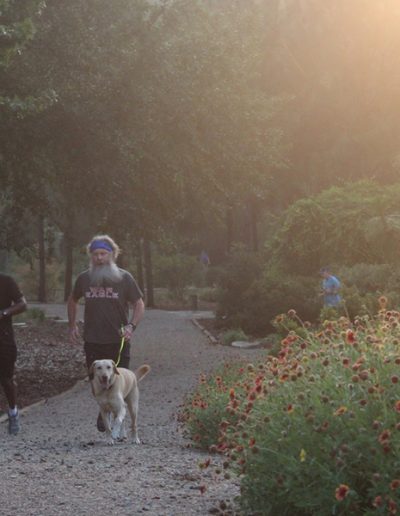 Dogtor Moose enjoys a run with parents during CWE in the Arboretum